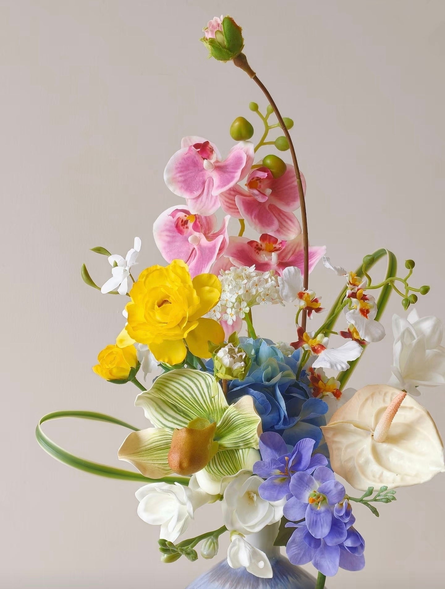 A Sunny Day in Bloom - close up of pink orchids, yellow ranunculus and blue hydrangea blooms