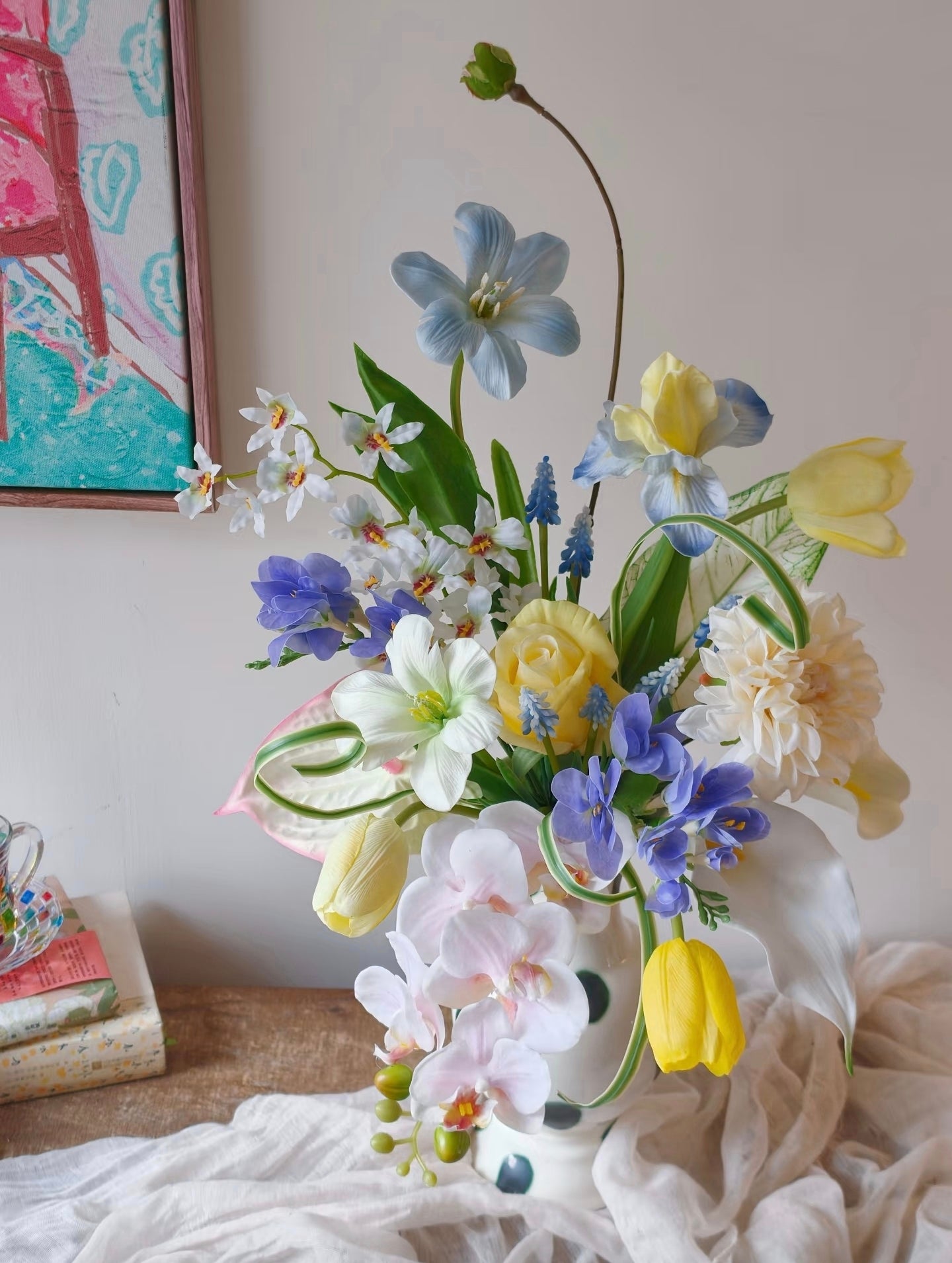 The Painter's Garden bouquet with polka dot vase styled with colourful art print - front view